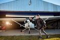 View of boy in aviator glasses playing with handmade small toy airplane near airfield Royalty Free Stock Photo