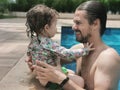 Brazilian Father and Daughter having fun at swimming pool