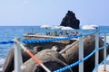 View of the breakwaters, volcanic rocks, the ocean, sun umbrellas and tourists in a seaside resort, Madeira, Potugalia