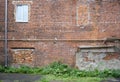 The brick wall of an old house, with traces of destruction and repair, one a bricked-up window, and the other is new plastic Royalty Free Stock Photo