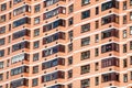 View of brick wall red contemporary apartment building with windows and balconies closeup Royalty Free Stock Photo