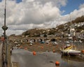 View of bridge at low tide boats moored on cloudy Spring day. Looe Harbour, Cornwall, UK