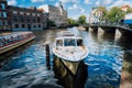 View on the bridge through the river channel with boat in front, typical picture of canals in Amsterdam