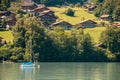 View of Brienz lake with clear turquoise water. Sailing boat. Traditional wooden houses on the shore of Brienz lake in Royalty Free Stock Photo