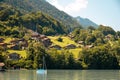 View of Brienz lake with clear turquoise water. Sailing boats. Traditional wooden houses on the shore of Brienz lake in Royalty Free Stock Photo