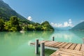 View of Brienz lake with clear turquoise water. Wooden pier. Traditional wooden houses on the shore of Brienz lake in Royalty Free Stock Photo