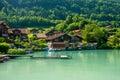 View of Brienz lake with clear turquoise water. Wooden pier. Traditional wooden houses on the shore of Brienz lake in