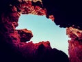 View of the bright blue sky through a gap in rocks