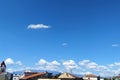 View of a bright blue sky with white clouds over the rooftops Royalty Free Stock Photo