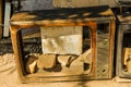 View of a broken antique television on the ground with bricks inside it