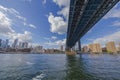 View of Brooklyn Bridge over Hudson River and skyscrapers of Manhattan against blue sky with white clouds. USA. Royalty Free Stock Photo