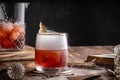 View of a brown cocktail in a glass placed n a wooden surface with other drinks