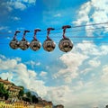 View of 5 bubble cabins of the Grenoble Bastille's cable car under a blue sky, over the city