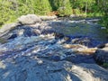 View of the bubbling waterfall with brown water on the Tokhmayoki River in Karelia from the ecological trail