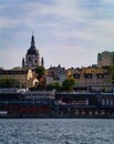 View of buildings by river against cloudy sky