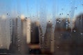 Window view on the city through raindrops