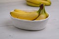 View on Bunch of organic banana fruits is into a white wicker basket Royalty Free Stock Photo