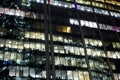 View of the burning windows of the modern office building at night. The work of people in the office. light of the night city Royalty Free Stock Photo