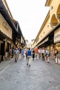 View of the businesses located to the sides of the Bridge on the river Arno, called `Ponte Vecchio` with people walking