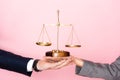 View of businessman and businesswoman holding golden scales on pink, gender equality concept