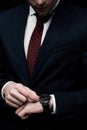 View of businessman checking time on watch isolated on black Royalty Free Stock Photo