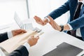 View of businessman gesturing near business partner giving envelope with money in office Royalty Free Stock Photo