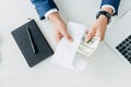 View of businessman holding envelope with dollar banknotes near laptop on table Royalty Free Stock Photo