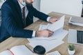 View of businessman looking at papers with graphs and charts while sitting at workplace Royalty Free Stock Photo