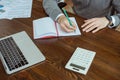 View of businessman writing in notebook near laptop, calculator and papers at table in office Royalty Free Stock Photo