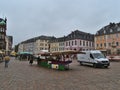 View of busy marketplace Hauptmarkt with weekly market in the historic center of Trier on cloudy summer day.