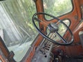 View of the cab of an old tractor. Steering wheel and interior of the cab. Agricultural machinery, selective focus