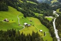 Homesteads in alpine valley lush green at river Austrian landscape aerial