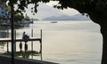 View of calm Lake Zugersee and a young girl sitting looking out over the lake