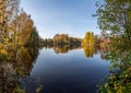 view of a calm river, autumn, Sunny day. In the foreground are beautiful twigs and leaves. Reflection Royalty Free Stock Photo