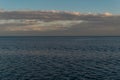 View of calm undulating .ripples water of Lake Baikal, sunset clouds on the horizon, blue sky