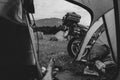 View from camp tent door. Motorcycle adventure bike on the background of green grass, forest and mountains under clouds sky,