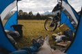 View from camp tent door. Motorcycle adventure bike on the background of yellow autumn grass, forest and mountains under clouds