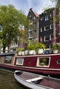 View of canal, a boat house with many flowers, trees and historical, traditional buildings Royalty Free Stock Photo