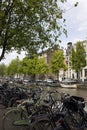 View of canal, parked boats, cars and bicycles,