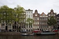 View of canal, parked boats, cars and bicycles,