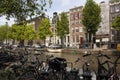 View of canal, parked boats, cars and bicycles