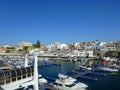 View of the canal port of Ciutadella de Menorca with various boats in the foreground and in the background of the blue sky the