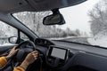 View from the car on the countryside winter road. Wide angle image. Hands of a female driver on the steering wheel. Winter road Royalty Free Stock Photo