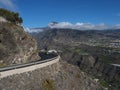 View on car at curved winding asphalt road in steep rocky mountain slope with subtropical volcanic landscape of La Palma