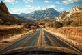 View from car driving down an open road with sprawling desert and mountain backdrop Royalty Free Stock Photo