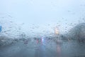 view from car on raindrops on window and road with police lights and silhouettes of cars driving behind him in rainy morning Royalty Free Stock Photo