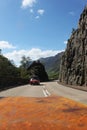 View from the car on the road with another car in Scottish Highlands