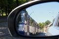 View in the car\'s side mirror of the approaching tram. Riga, Latvia - 15 Jun 2021