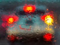 View of car traffic through a wet windshield - Traffic jam from a driver seat perspective on a rainy day. Tail-lights of the car Royalty Free Stock Photo