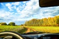 View from car window on beautiful landscape with field and road. Autumn nature with sky full of white clouds. Travel concept Royalty Free Stock Photo